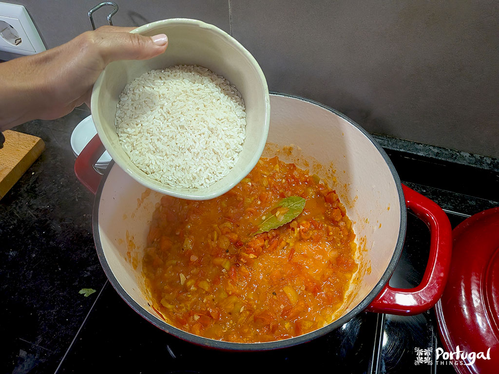 Uma pessoa preparando Arroz de Tomate despeja arroz numa panela, seguindo uma receita deliciosa.