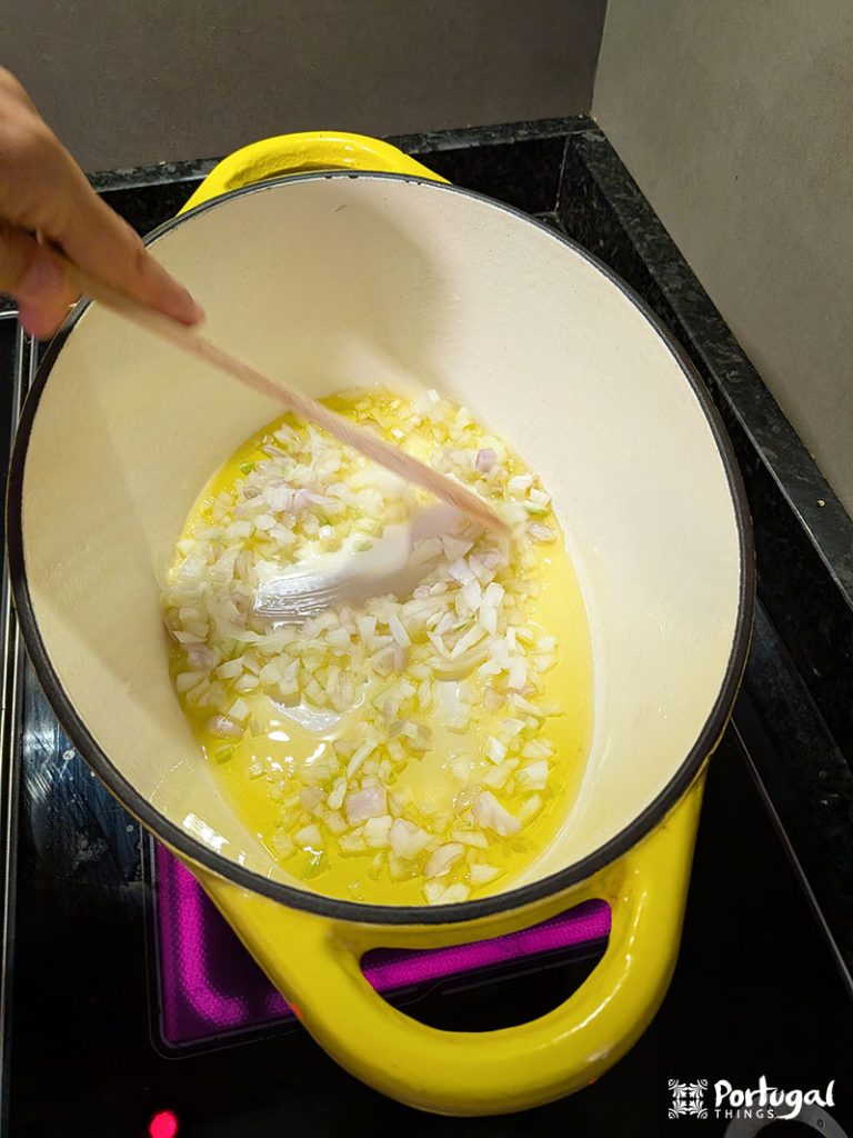 A person stirring the ingredients in a pot, preparing a delicious Christmas Roupa Velha recipe.