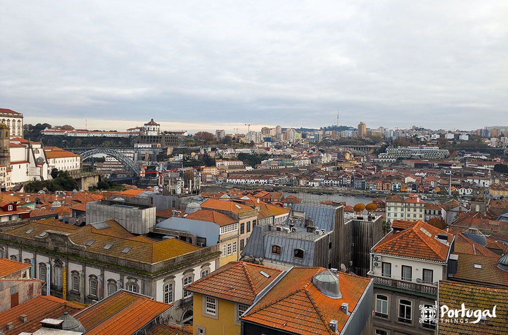 vista do Porto com vários prédios, a ponte D. Luís e a Serra do Pilar