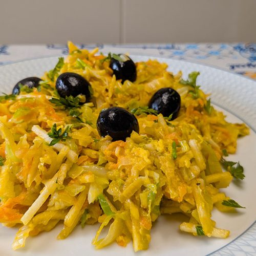 Um prato de legumes à Brás decorado com azeitona preta e salsa