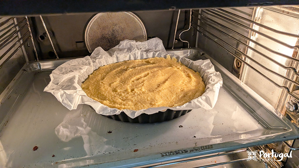 a tart tin with the almond tart base inside the oven