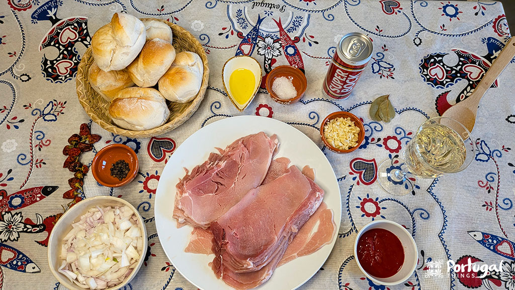 varios ingredientes para fazer as bifanas à moda do porto estão dispostas em cima de uma toalha
