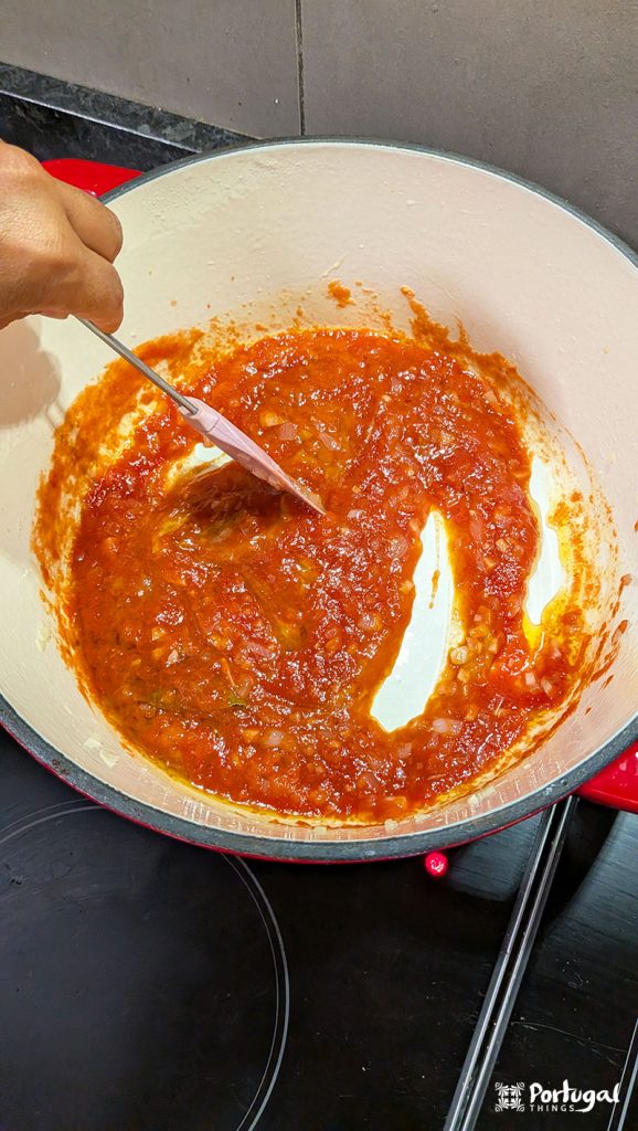 Red porto style bifana sauce cooking in a saucepan.