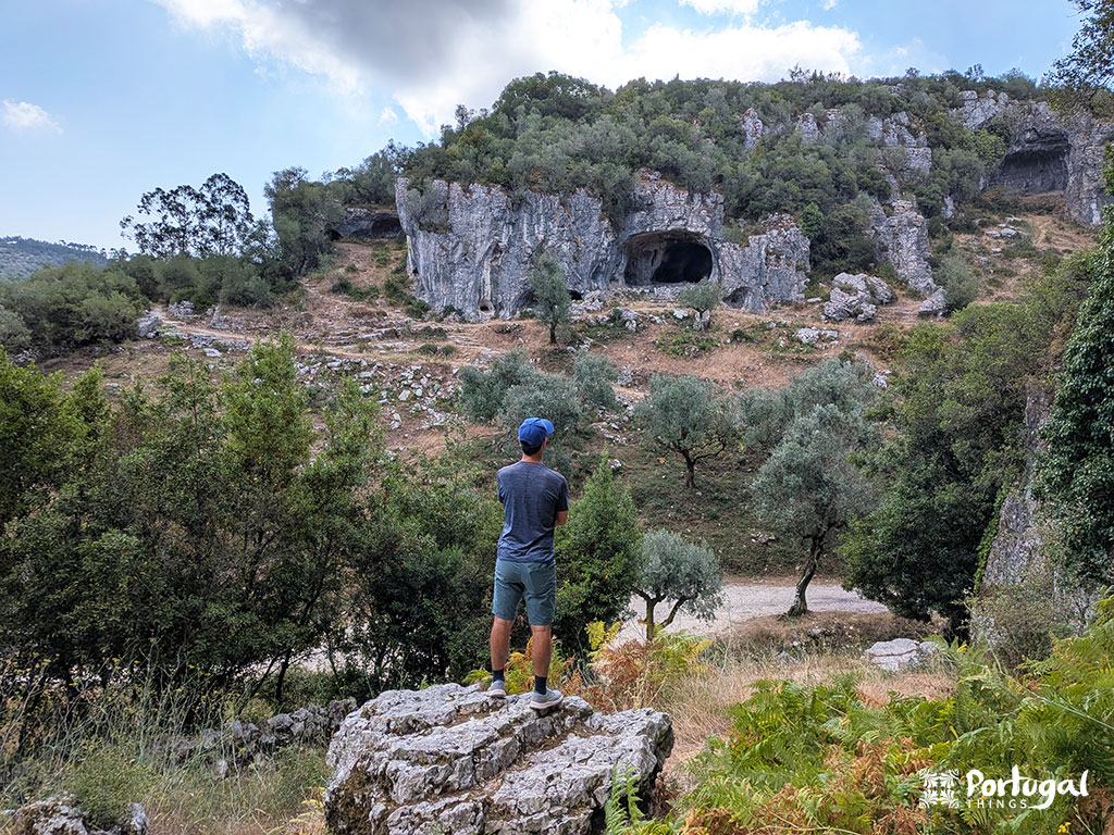 Buracas do Casmilo: Como Fazer o Trilho e Visitar as Grutas 10 Uma pessoa encontra-se em cima de uma rocha a observar as cavidades da montanha