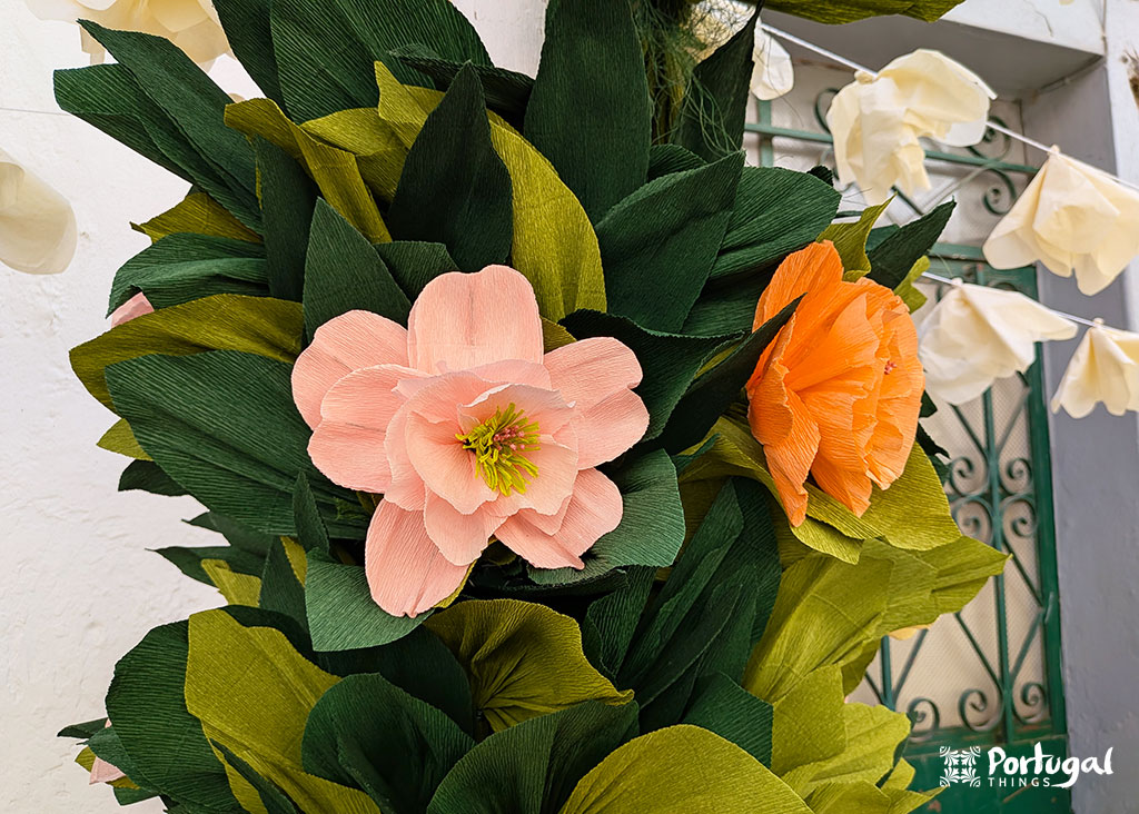 uma flore rosa e outra laranja com folhas verdes tudo feito em papel