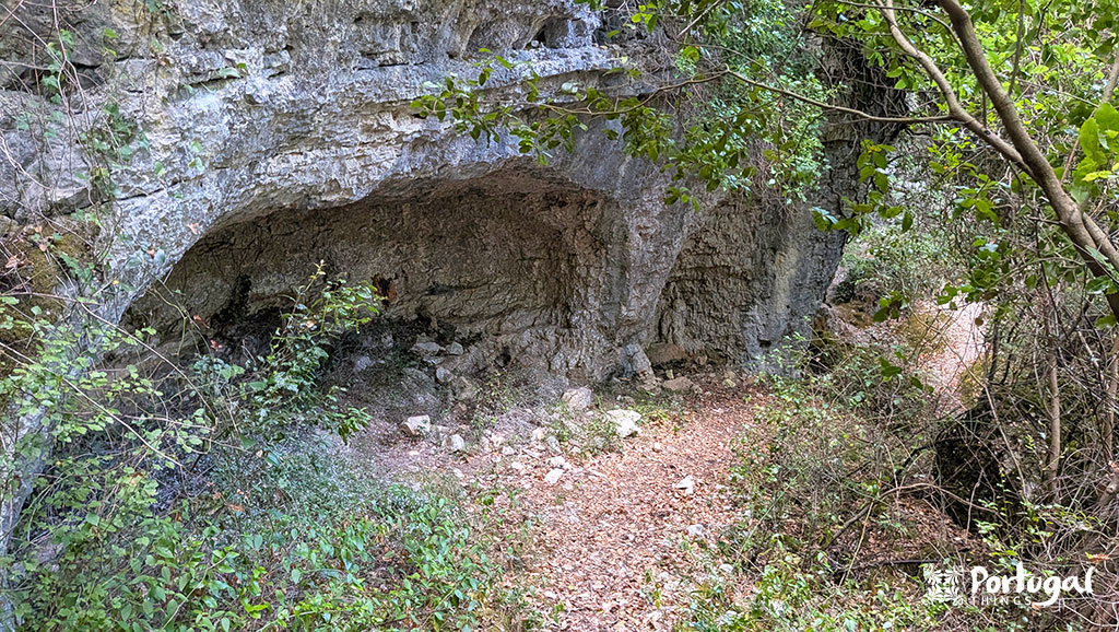 Buracas do Casmilo: Como Fazer o Trilho e Visitar as Grutas 8 Cavidades numa montanha cinzenta rodeada de arvores e vegetação