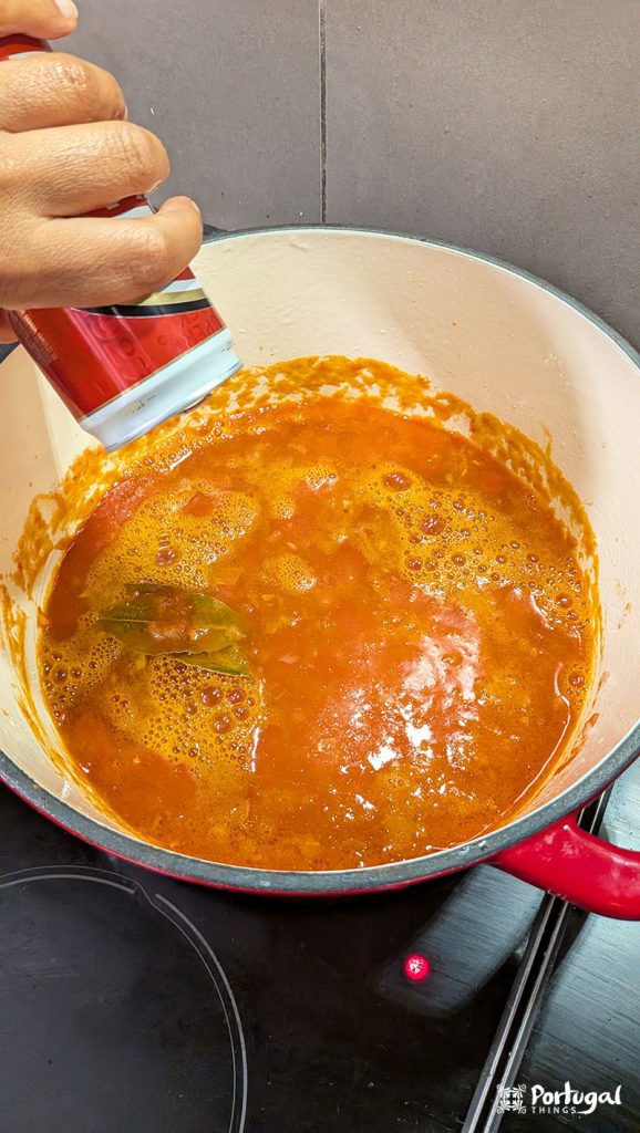 Adding beer to the bifana sauce.