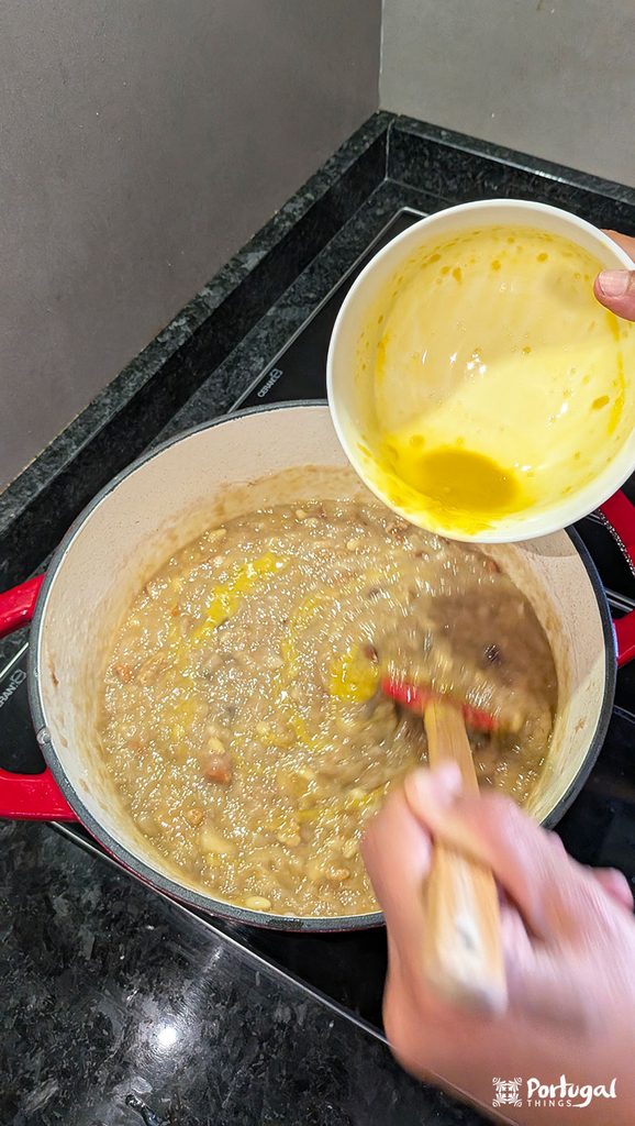 Mexidos: A Traditional Portuguese Christmas Dessert 9 Egg yolks are being added to a bowl of mexidos while a hand stirs with a spatula.