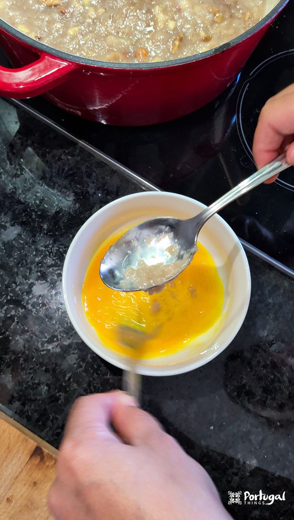 Mexidos: A Traditional Portuguese Christmas Dessert 8 One hand beats egg yolks in a bowl with a fork while the other adds a spoonful of mexidos.